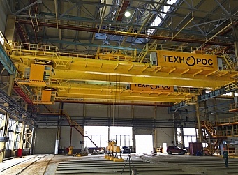 Special bridge crane with a flexible  and a rigid traverse suspension and rotating trolley